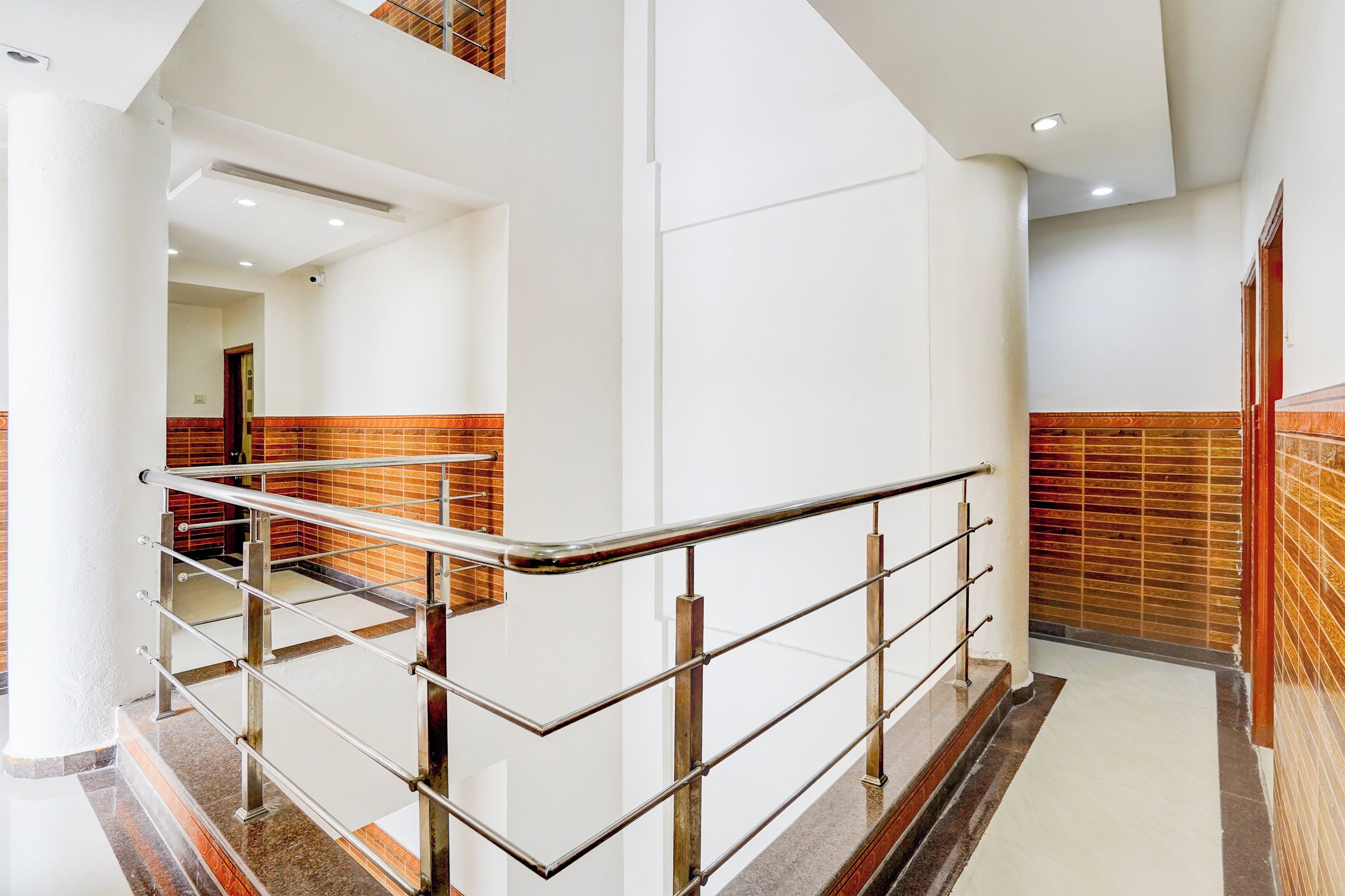 A modern interior with a metal staircase, white walls, and a patterned wall detail.