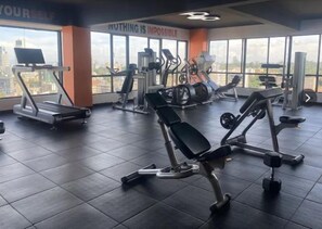 A gym with various exercise equipment, large windows, and motivational wall text. - Finewood Residency View Palace Apartment (Nairobi)