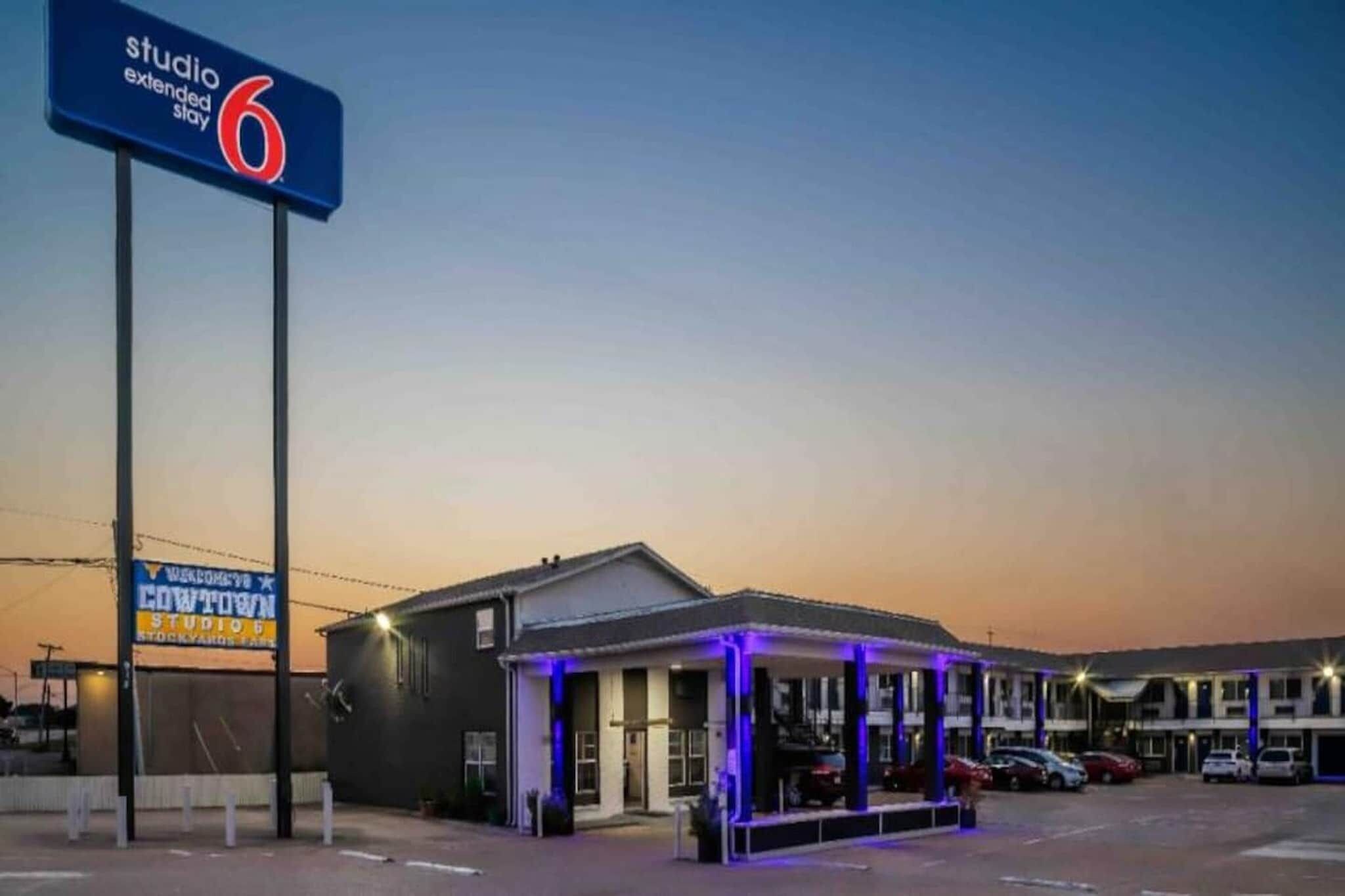 Ein Motel mit einem Schild für 'Studio Extended Stay 6' und einem 'Welcome to Cowtown' Schild.