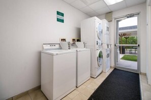 A laundry room with two front-loading washers and dryers, a tiled floor, and a door leading outside. - 2 Full Beds | Mob Acc Tub Nsmk Kitchen (INGLESIDE)