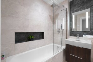 A modern bathroom with a glass-enclosed shower, a built-in sink, and a dark wooden vanity. - The Isleworth 2BR 2BA with Gated Parking & Balcony (Isleworth)