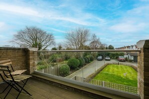 A balcony with a view of a green lawn and a street. - The Isleworth 2BR 2BA with Gated Parking & Balcony (Isleworth)