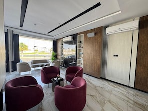 A modern lobby with a seating area, marble flooring, and a view of the outdoors. - Niyama Land Hotel (Umluj)
