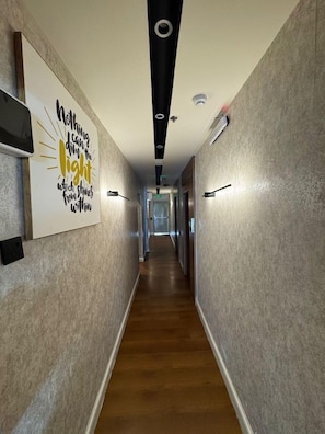 A hallway with a motivational quote on the wall, a fire alarm, and a ceiling light fixture. - Niyama Land Hotel (Umluj)