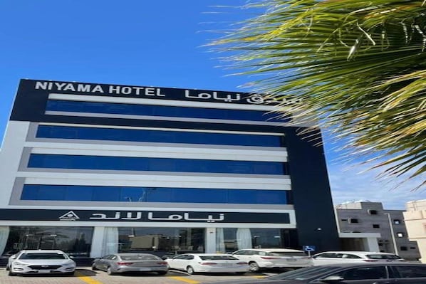 Moderni hotellirakennus, jonka yläpuolella on selkeä kyltti, jossa lukee: »NIYAMA HOTEL LOU».