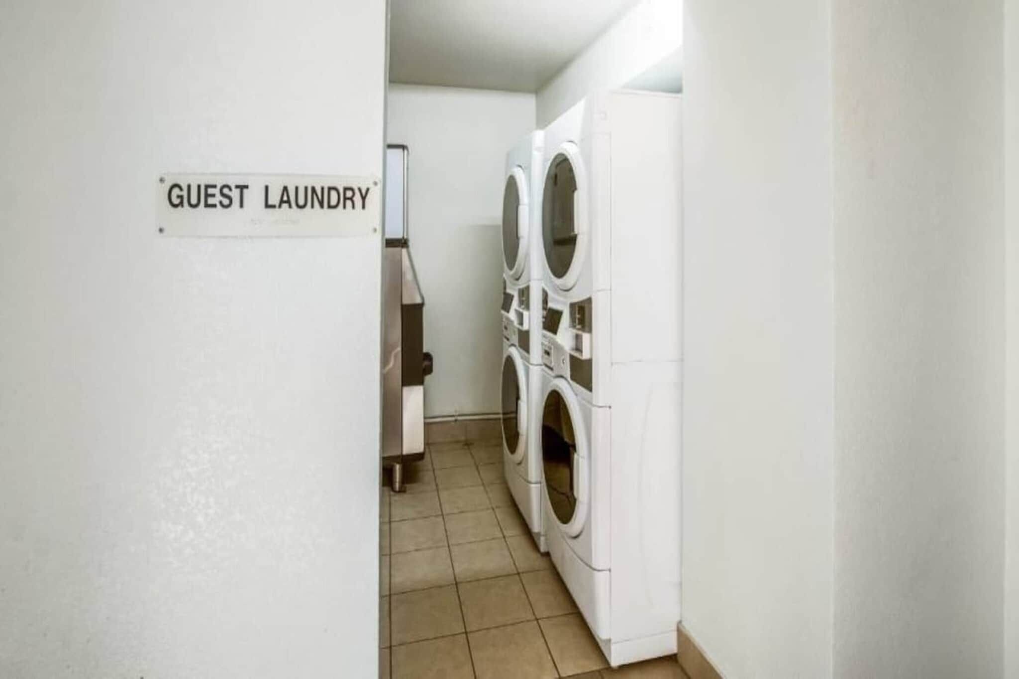 A guest laundry area with two washing machines and a sign indicating it's for guests.