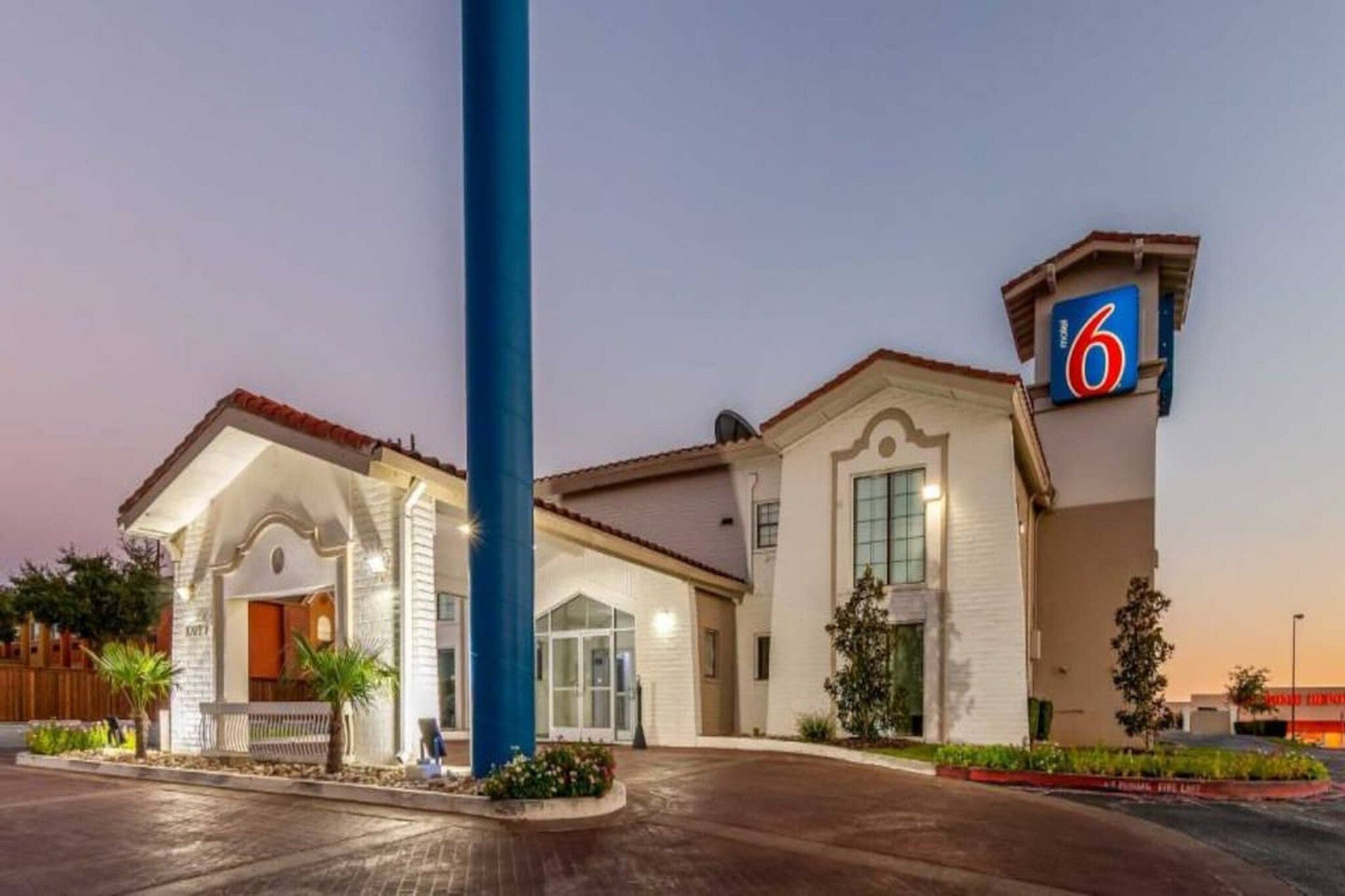 A hotel with a prominent '6' sign, a covered entrance, and a well-lit facade.