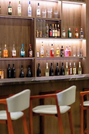 A bar area with shelves of various liquor bottles and glasses. - Brava Mundo Boutique Hotel (Itajai)