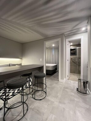 Un interior moderno con una zona de bar, una cama y una ducha.