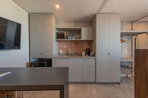 Una cocina moderna con electrodomésticos integrados, un televisor de pantalla plana y un comedor.