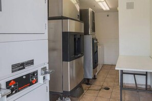Una cocina con electrodomésticos de acero inoxidable, incluyendo un refrigerador, horno y microondas.