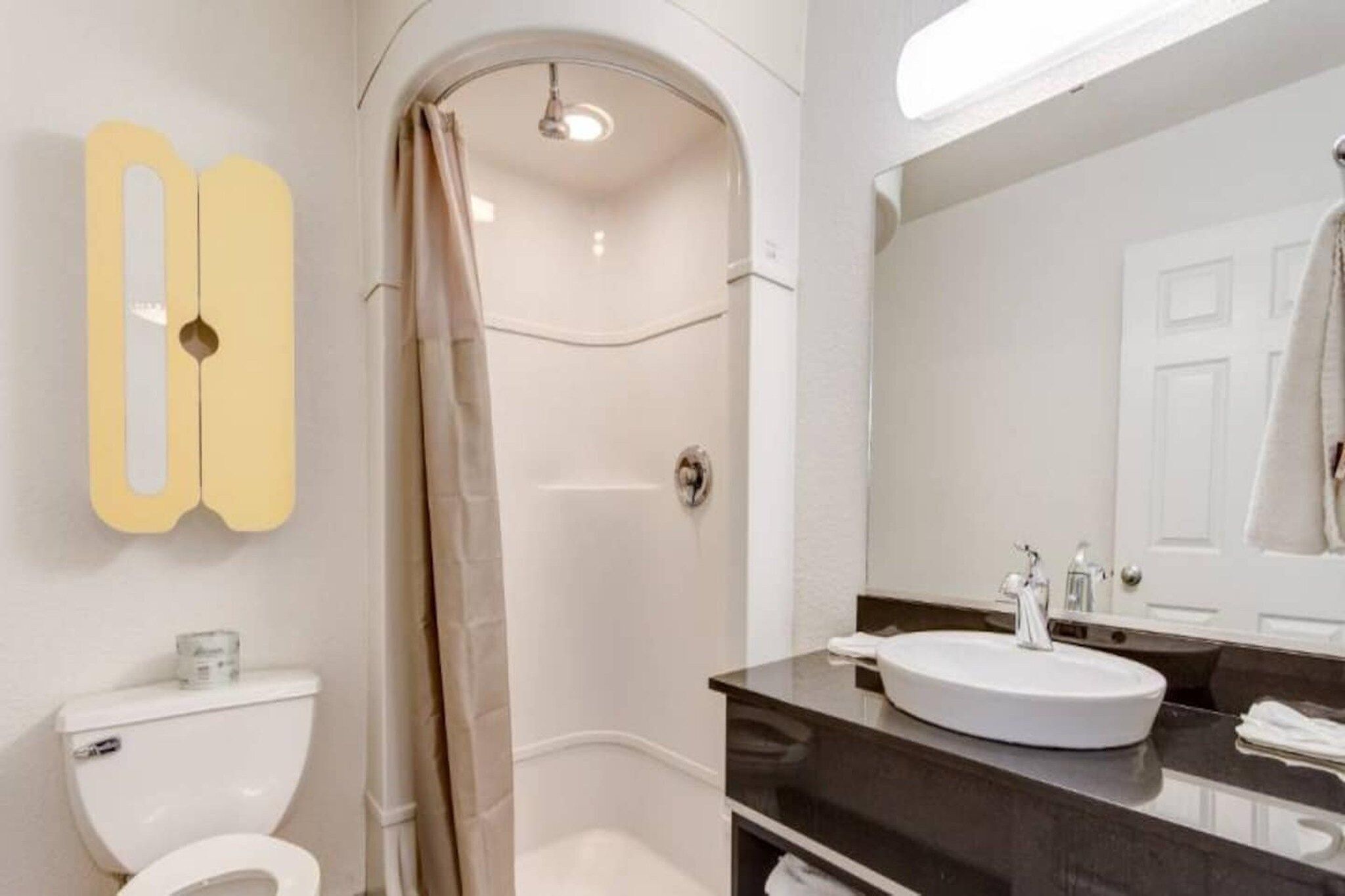 Un bagno con il water, doccia e lavandino.
