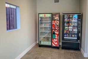 Un corridoio con due distributori automatici, uno con bevande e l'altro con snack.