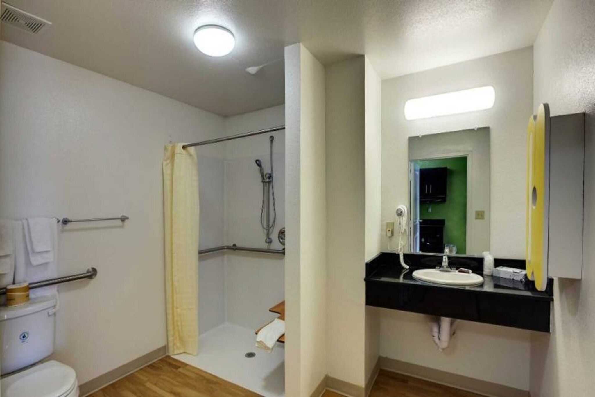 Une salle de bain avec douche, toilettes et lavabo.