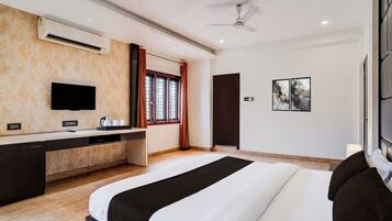 A modern hotel room with a bed, a desk with a flat-screen TV, a ceiling fan, and a window with curtains.