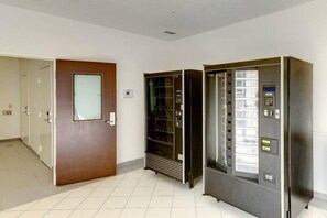 Ett hotellrum med en dörr av trä, en minibar och ett inbyggt kylskåp.