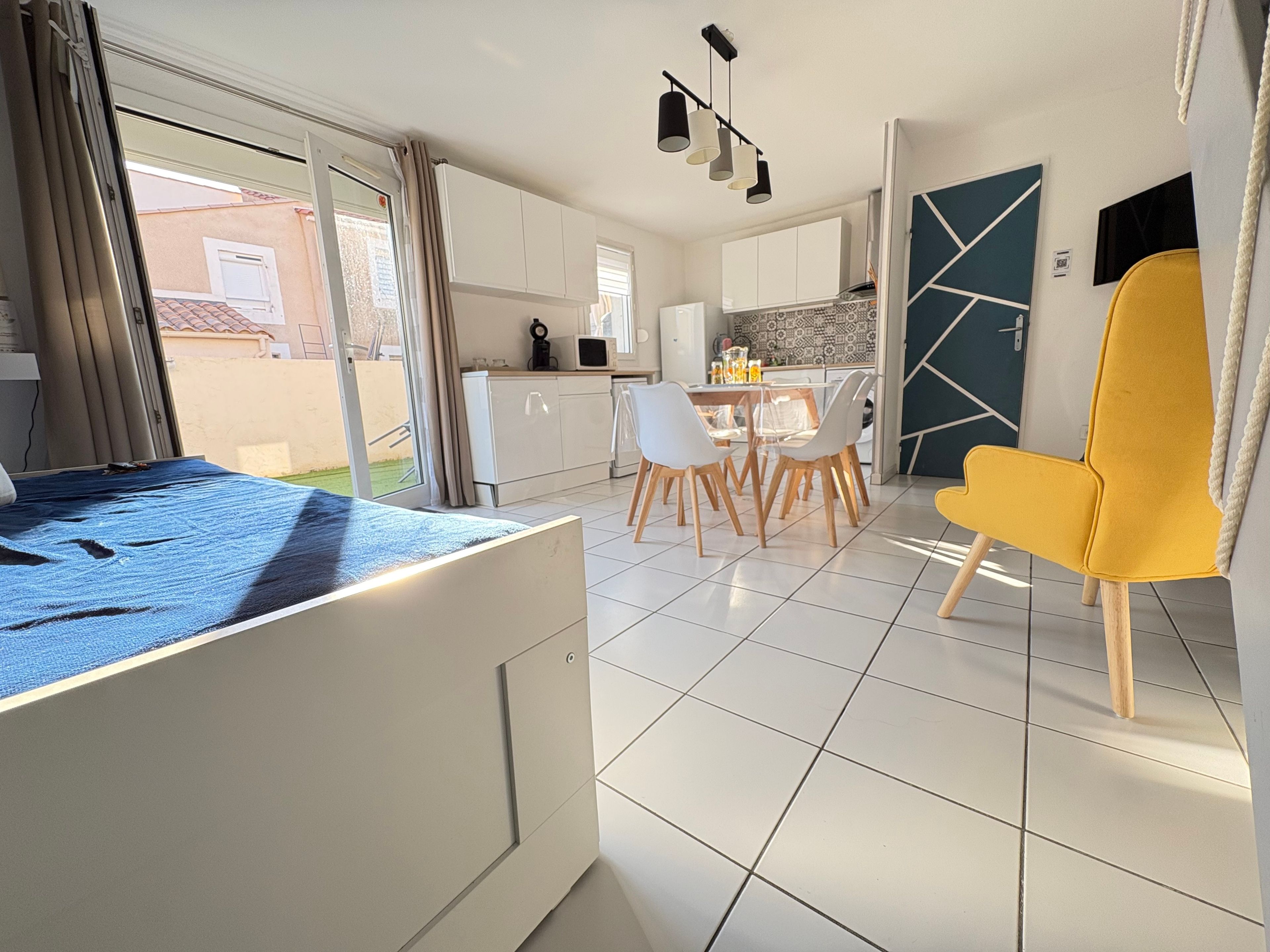Un intérieur moderne comprenant un lit, un coin repas et une cuisine.