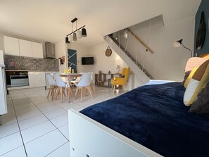 A compact living space with a bed, dining area, kitchen, and a staircase. - Holiday Home 'Maison De La Gardiole' with Shared Pool, Wi-Fi and Air Conditioning (Frontignan)