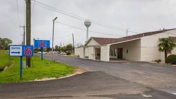 A motel with a sign indicating 'ENTER 6' and a building with a sloped roof.