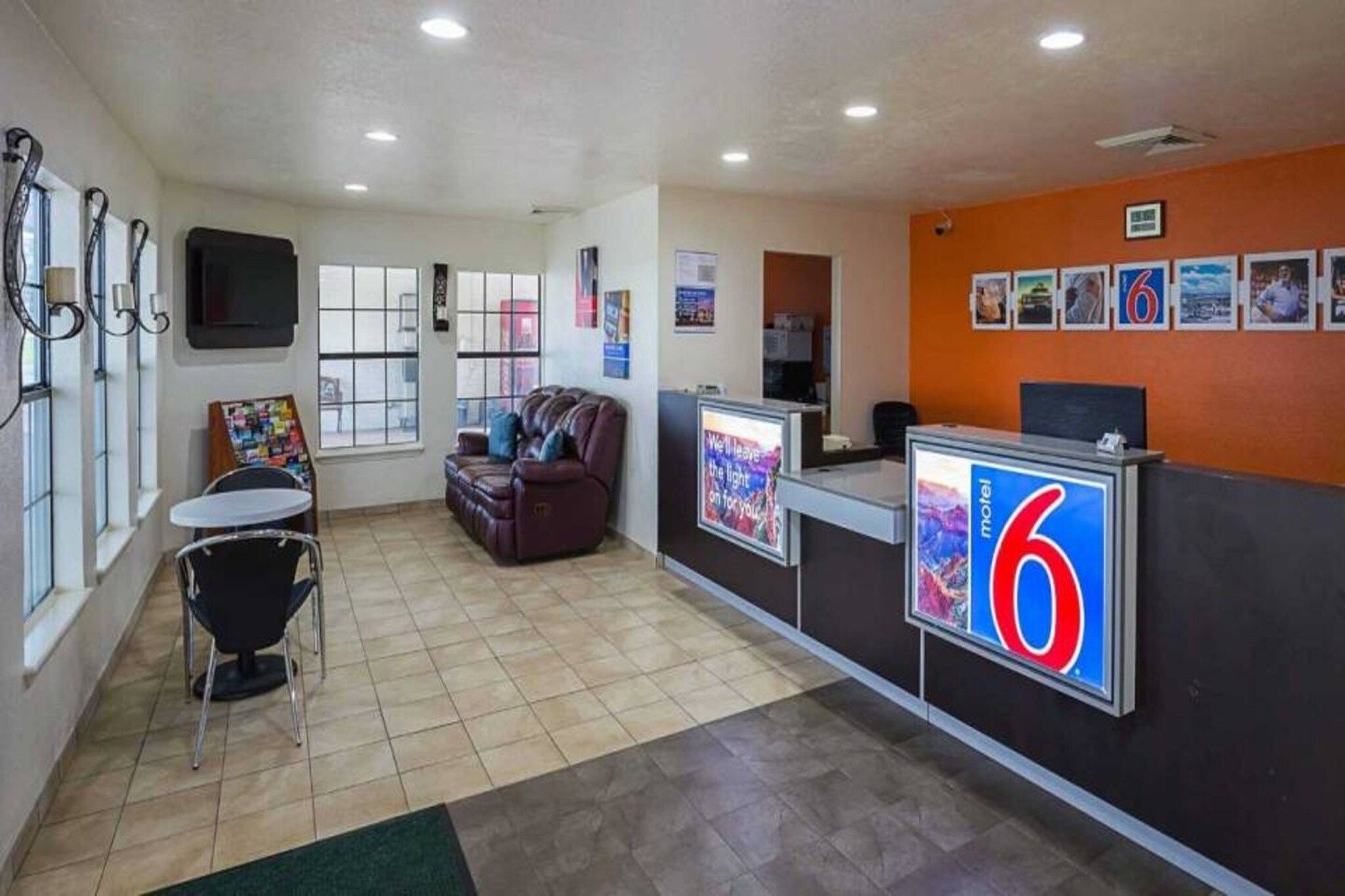 A lobby with a reception desk, a seating area, and a wall with framed pictures.
