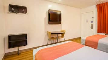 A hotel room with two beds, a desk, a chair, a TV, and a coat rack.