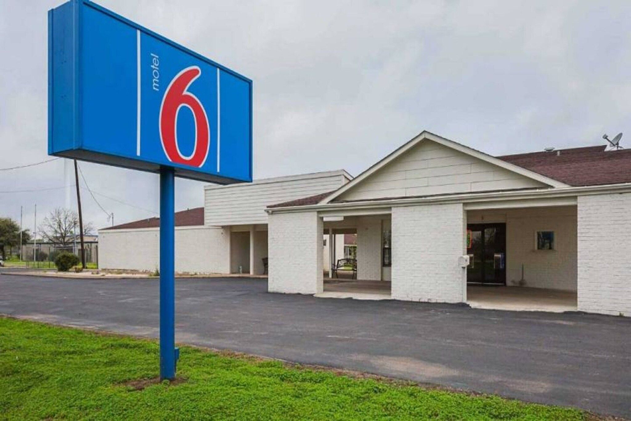Un motel avec une enseigne bleue bien visible, sur laquelle est inscrit le chiffre 6.