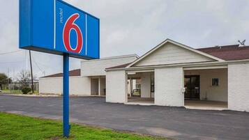 Un motel avec une enseigne bleue bien visible, sur laquelle est inscrit le chiffre 6.