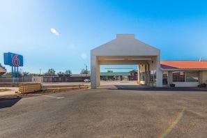 Um posto de gasolina com uma grande placa azul indicando o número 6.
