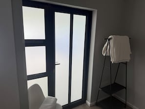 A bathroom with a large window, a towel rack, and a white towel. - Stellenbosch On the Go! (Stellenbosch)