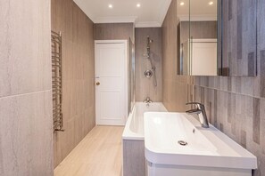 Une salle de bain moderne équipée d’une baignoire, d’une douche et d’un lavabo.