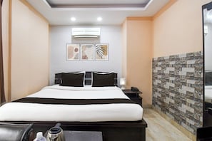 A hotel room with a bed, bedside table, lamp, and artwork on the wall. - Super Hotel O New Alipore (Kolkata)