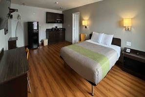 A hotel room with a bed, a desk, a kitchenette, and a bathroom. - 1 Queen Bed | Non-Smoking, Kitchen (Abilene)