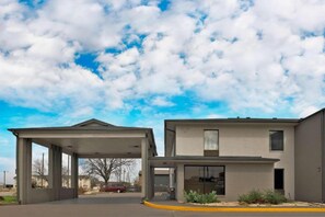 A two-story building with a covered parking area and a clear sky. - 2 Queen Beds | Smoking, Kitchen (Austin TX)
