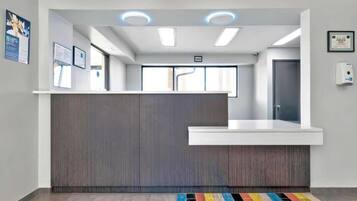 A reception area with a counter, a door, and a wall-mounted hand sanitizer dispenser.