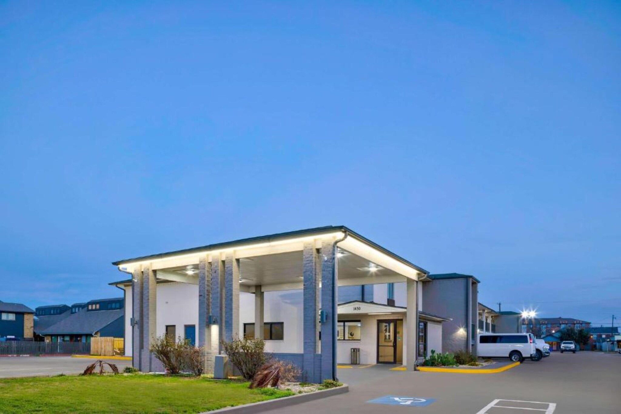 A modern building with a covered entrance and a parking lot.