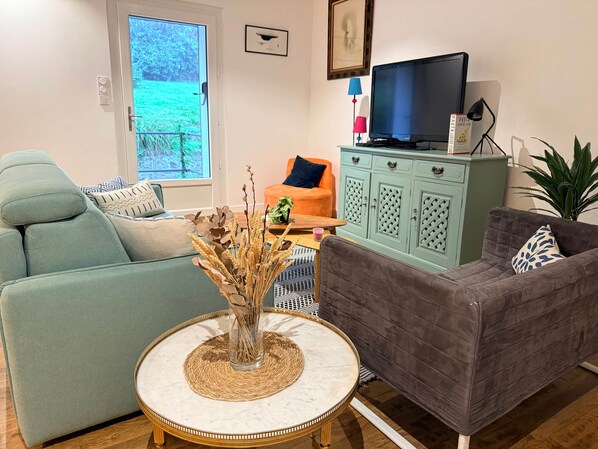 A living room with a sofa, a coffee table, a television, and a cabinet.