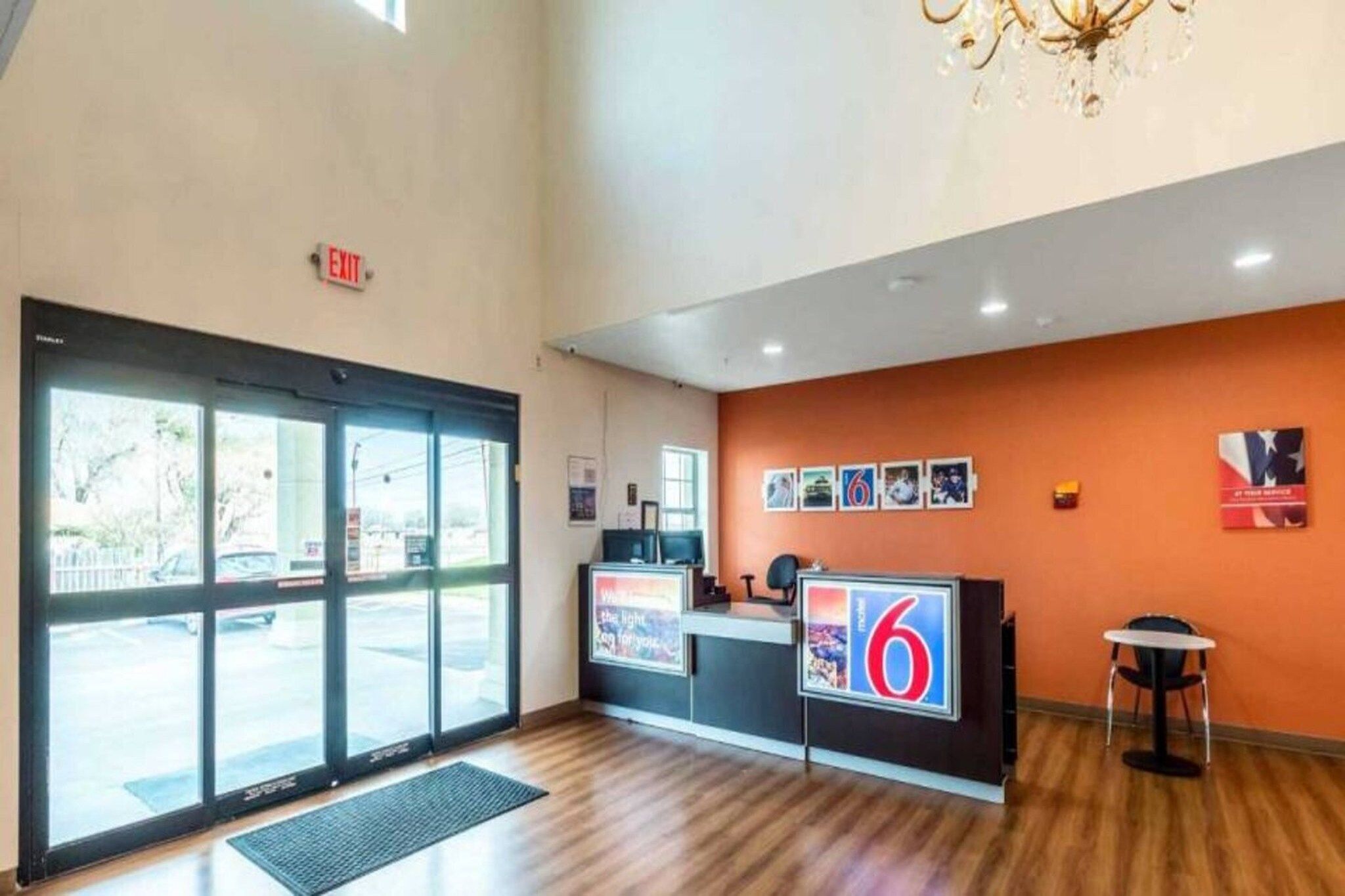 A reception area with a large glass door, a reception desk, and a wall with framed pictures.