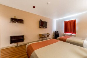 A hotel room with two beds, a desk, a television, and a minibar.
