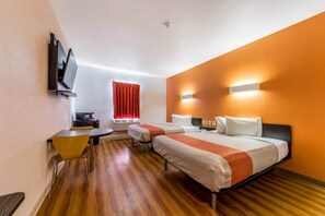 Habitació d'hotel amb dos llits, escriptori, cadira, televisió i finestra amb cortines vermelles.