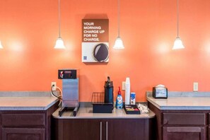 A hotel reception area with a coffee machine, a scale, and a sign indicating free morning charge.
