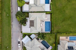 Un barrio residencial con varias casas, una piscina y una calle.