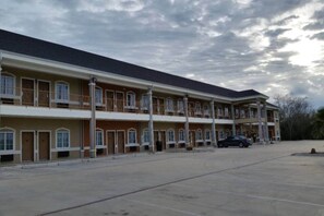 Hotel com vários andares, pátio central e estacionamento.