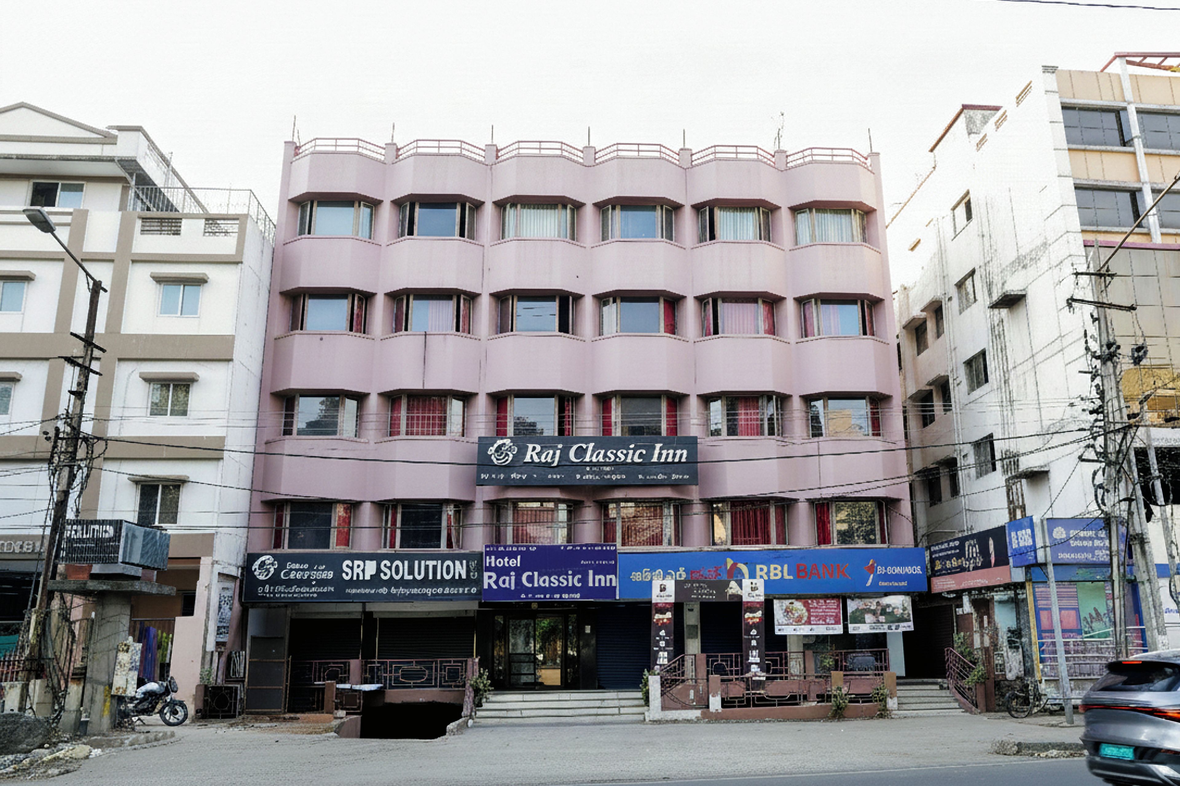Un immeuble à plusieurs étages portant une enseigne indiquant « Raj Classic Inn ».