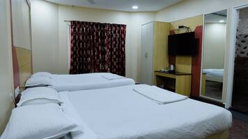 A hotel room with two beds, a television, a desk, and a wardrobe.