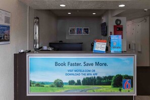 A reception desk with a digital screen displaying a booking message.