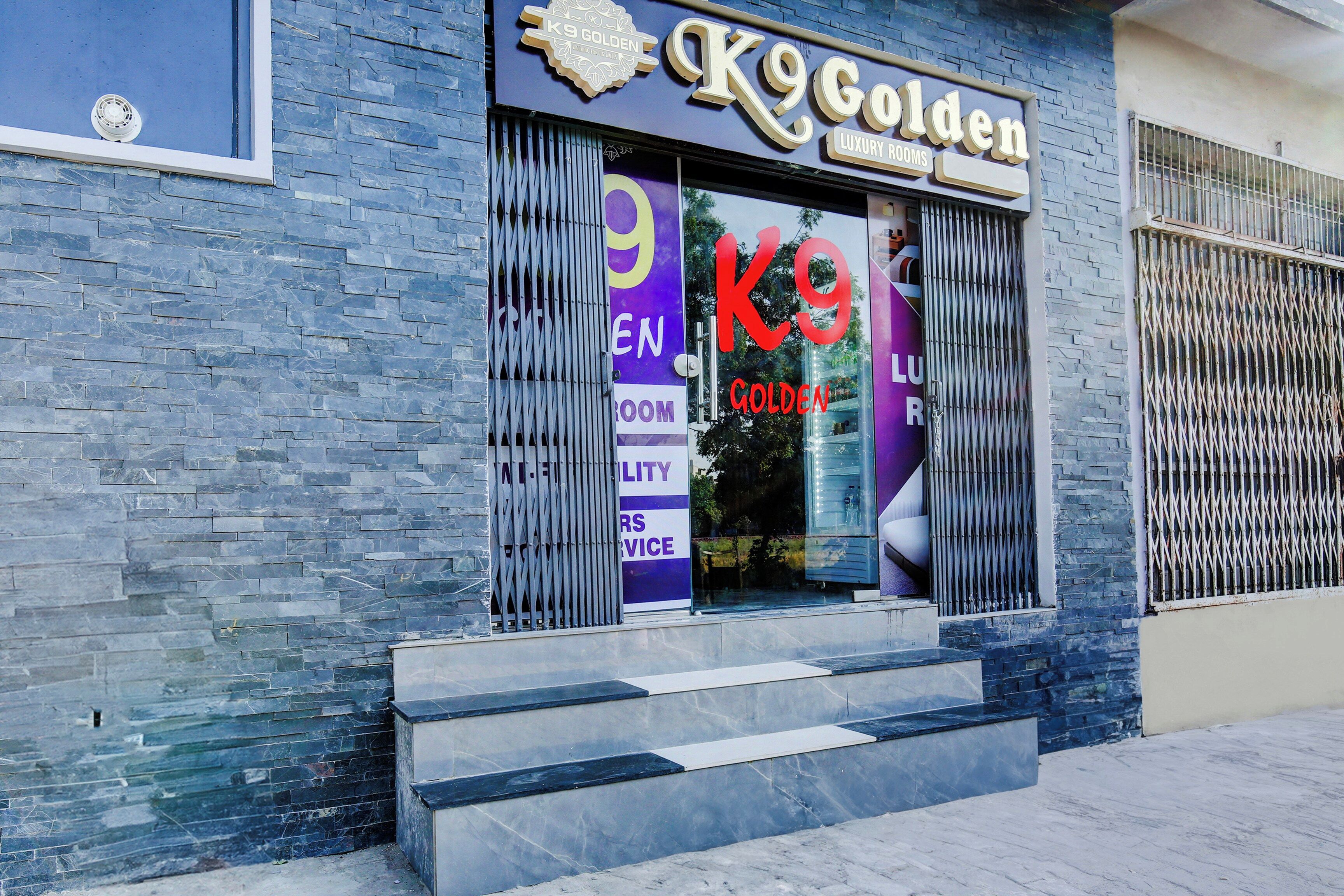 A hotel entrance with a sign reading 'K9 Golden Luxury Rooms'.