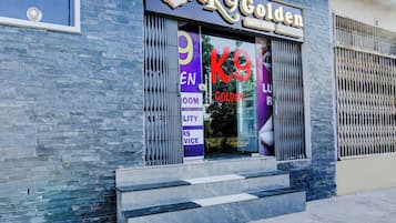 A hotel entrance with a sign reading 'K9 Golden Luxury Rooms'.