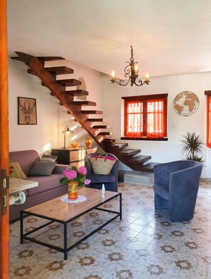 Ein modernes Wohnzimmer mit einer Holztreppe, einer Kristallleuchtre und einer Wanddekoration mit Globus.