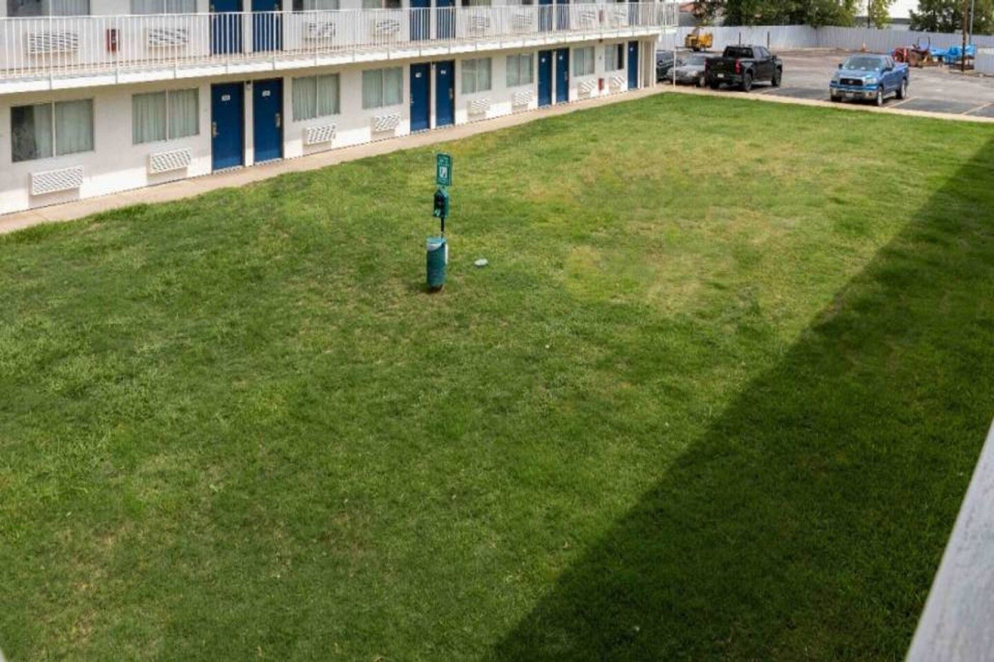 A grassy courtyard with a building in the background.