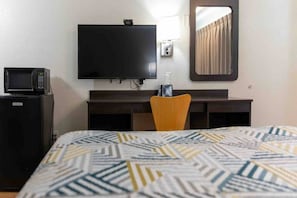 A hotel room with a bed, a desk, a chair, a television, and a microwave. - 1 Queen Bed | Smoking, Micfridge (LUFKIN)